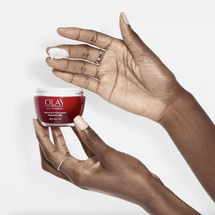 Woman holding bottle of Olay Regenerist Moisturizing Cream