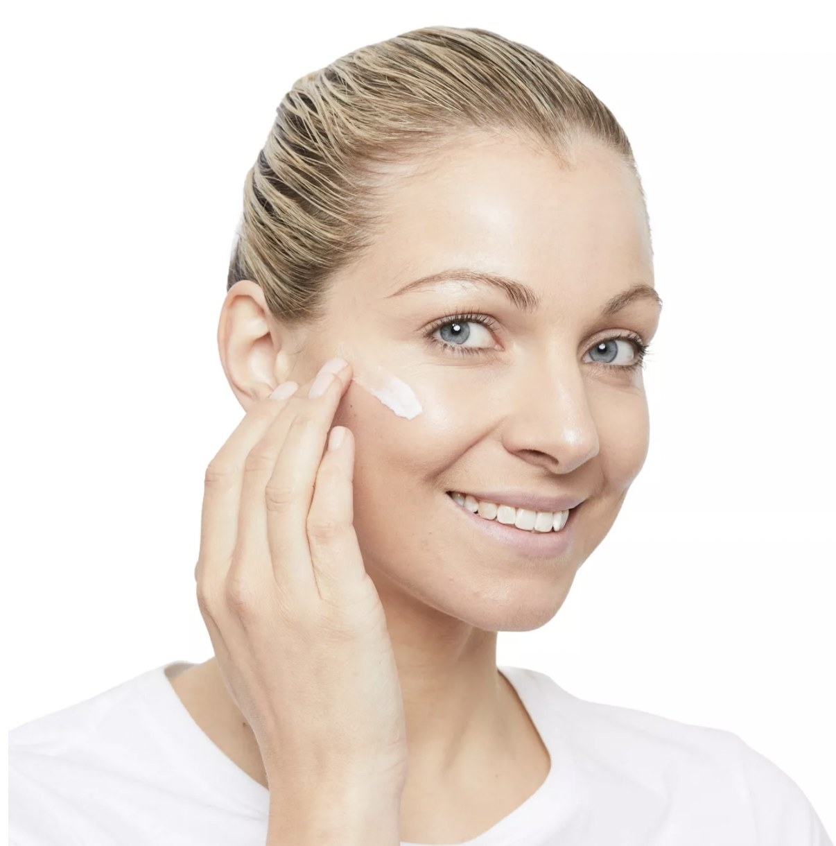 Woman rubbing No7 exfoliator cream on her cheek
