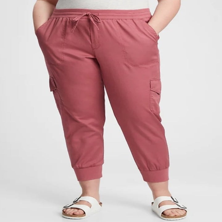 A model wearing a pair of pink rose ribbed cargo utility joggers