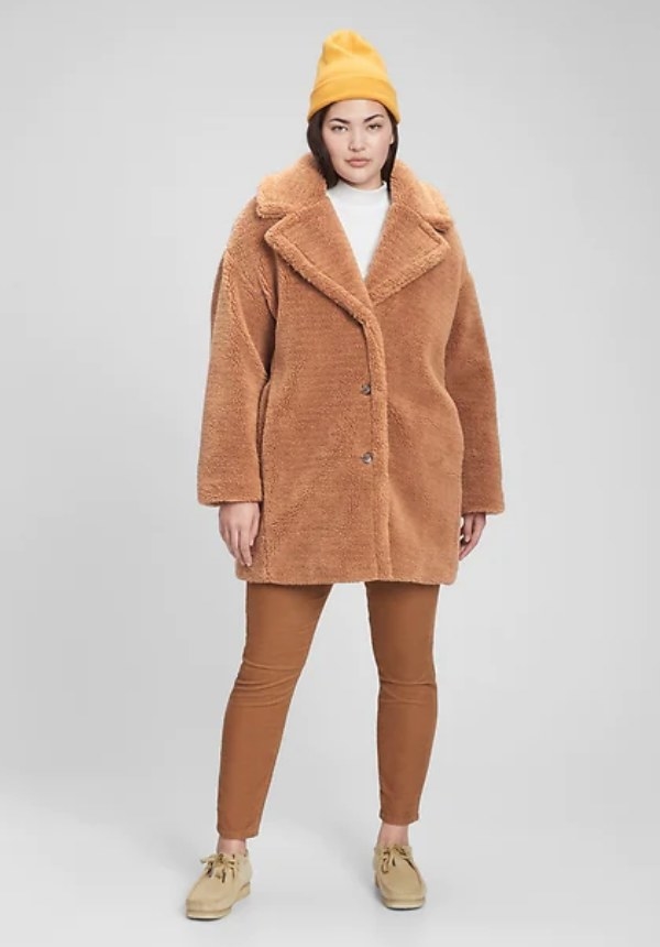 A model wearing a brown sherpa coat