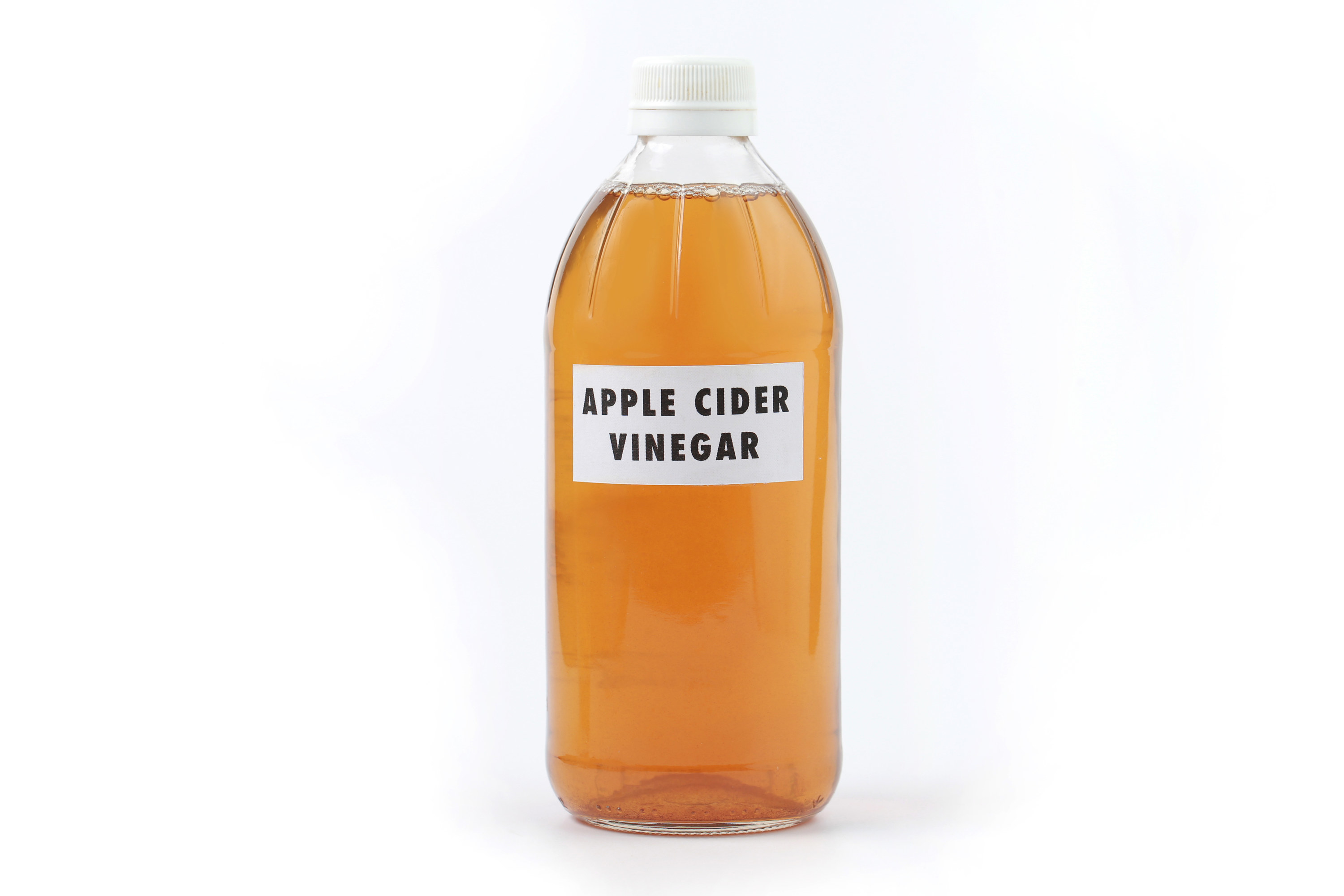 A bottle of apple cider vinegar against a white background