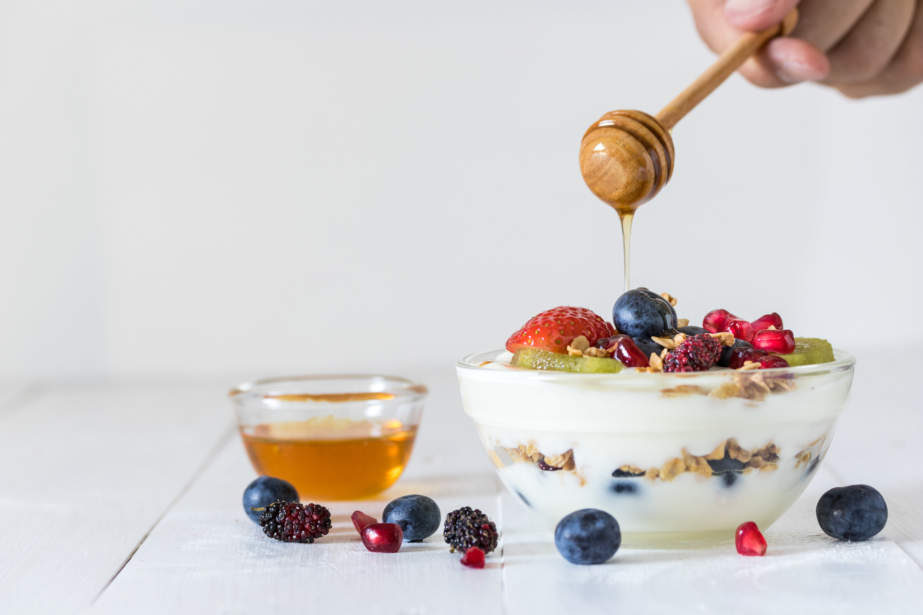 A big bowl of yogurt, berries, and honey