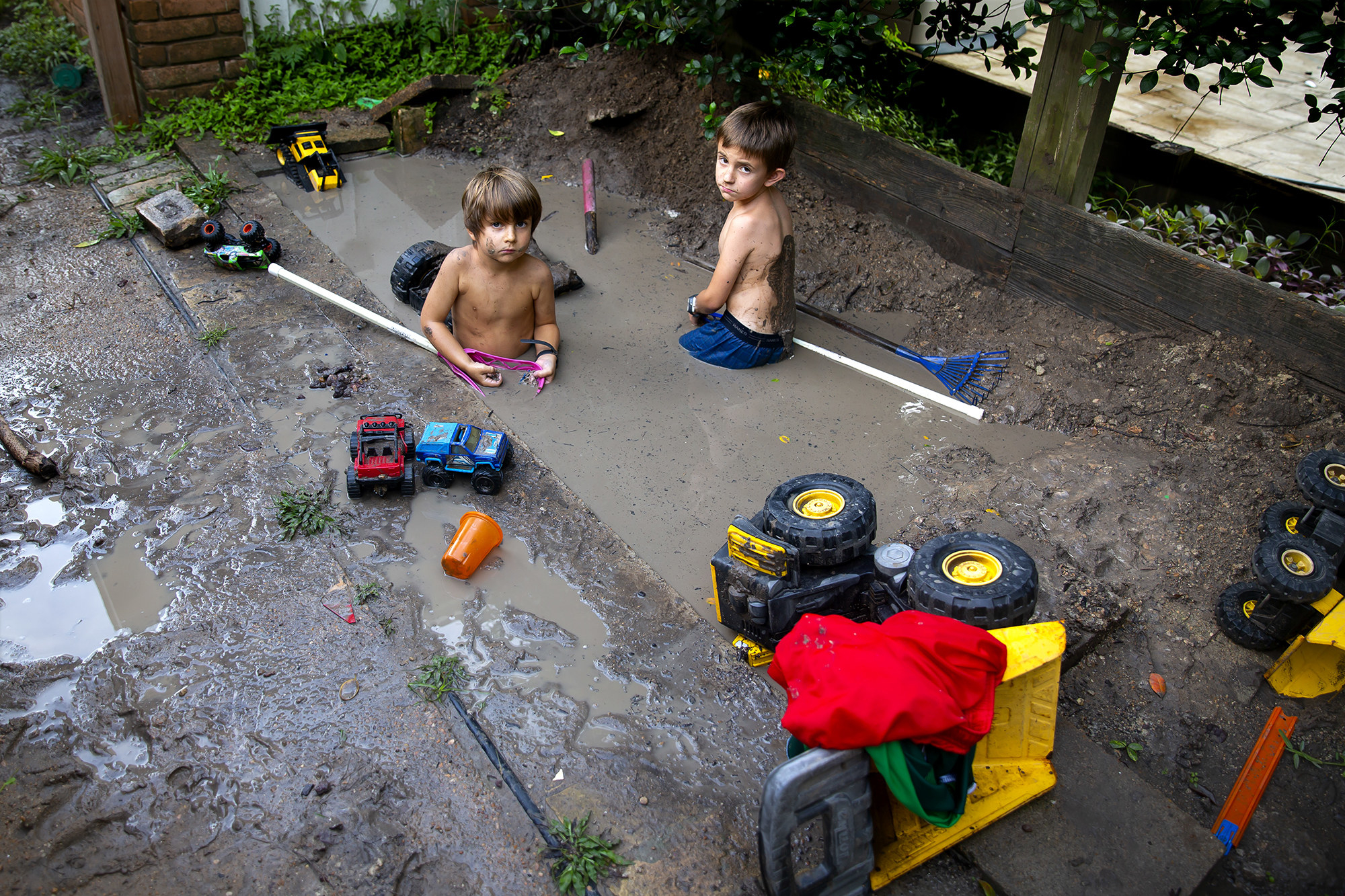 Two boys playing in the mud