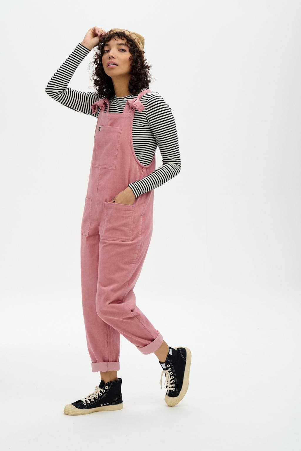 a model wearing the dusty pink corduroy overalls