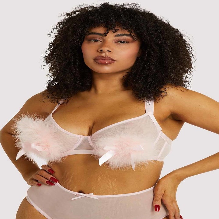 model with stretch marks wearing fluffy pompom pink lingerie set
