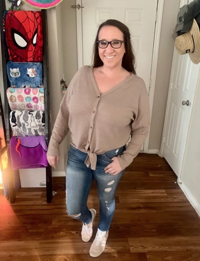 A reviewer wearing a tan top and jeans
