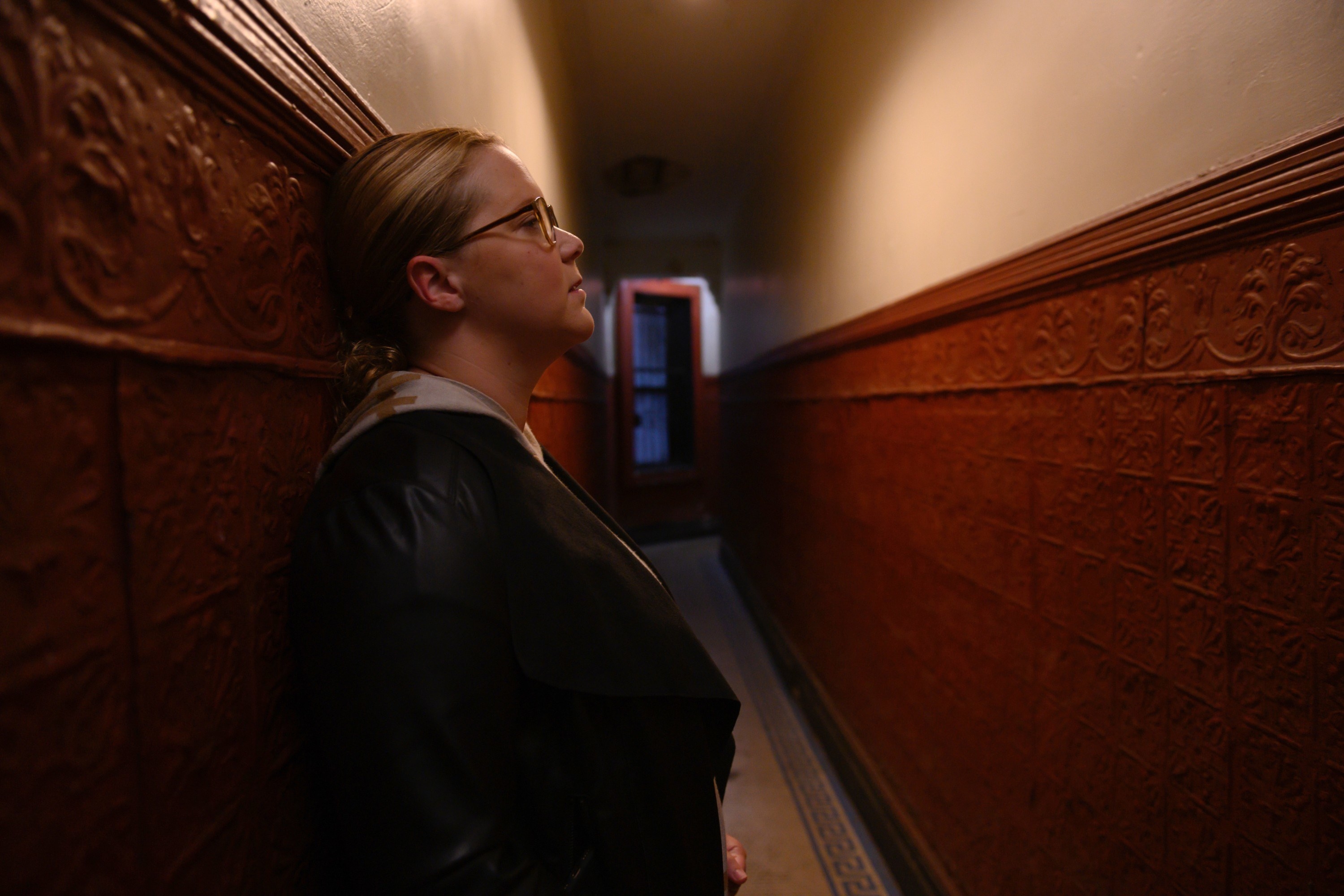 Amy Schumer leans in a hallway