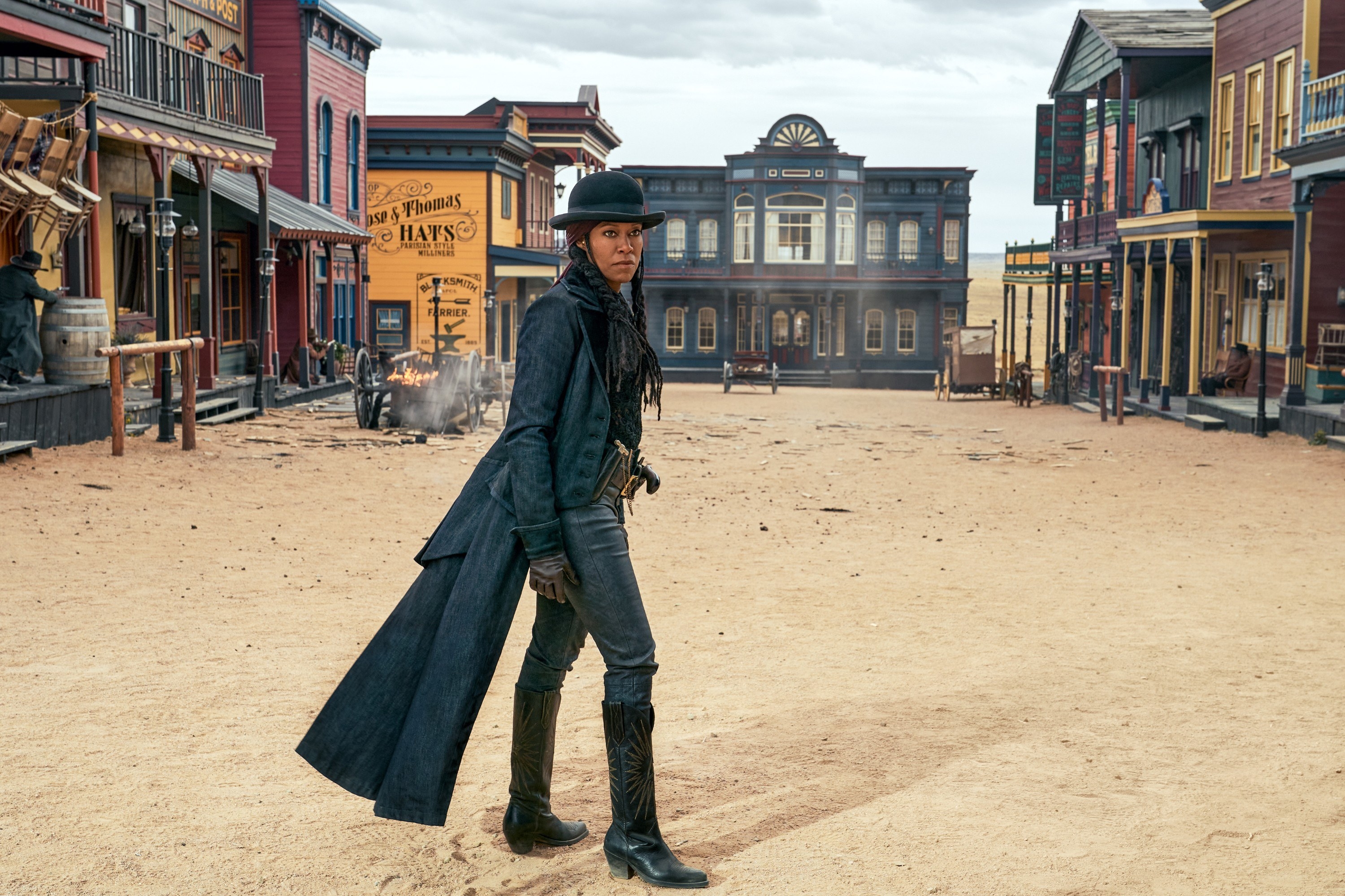 Regina King stands in the dusty main street of a town in the wild west