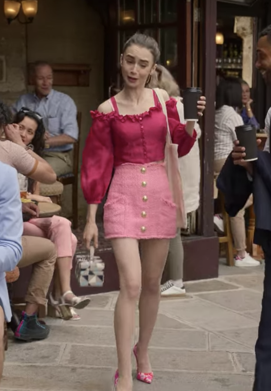 Emily wearing a tweed skirt with large buttons and long-sleeved, off-the-shoulder blouse, and pumps