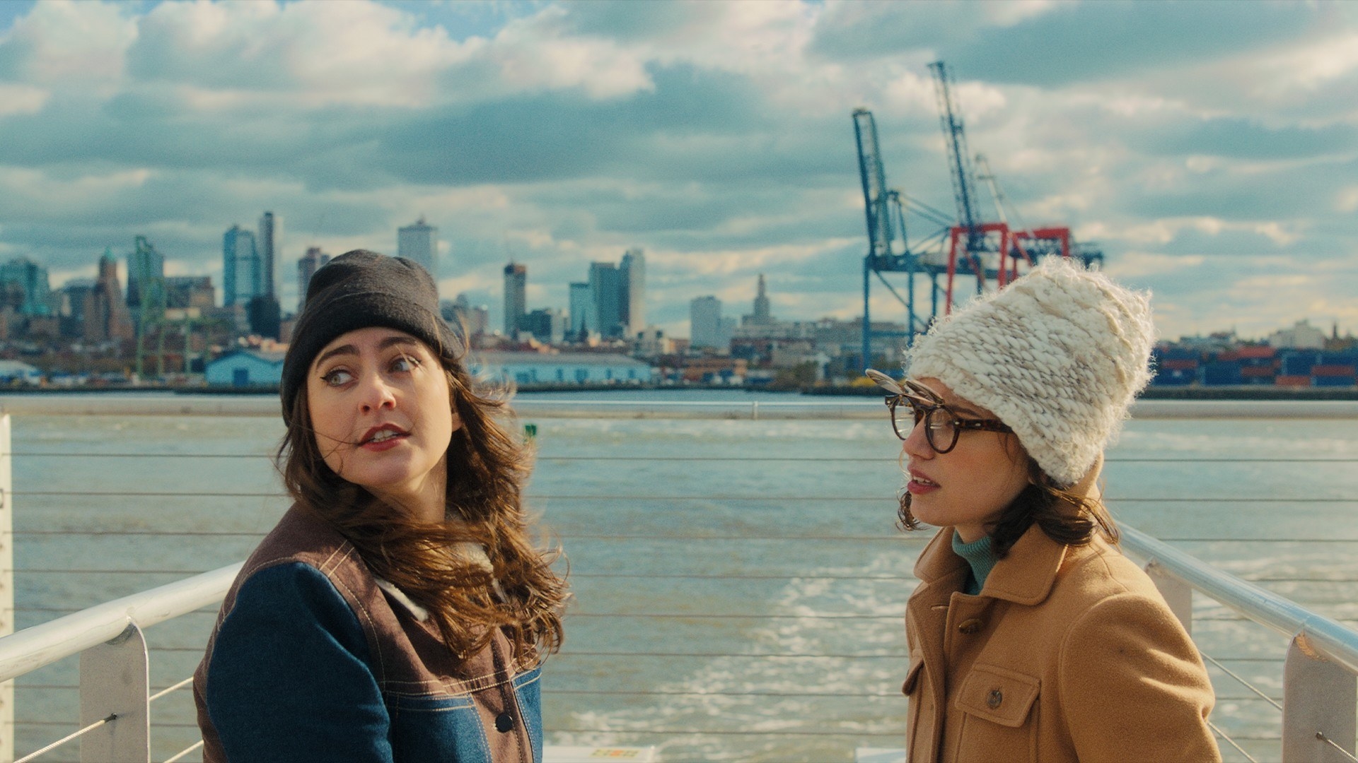 Catherine Cohen and Francesca Reale stand on a boat looking out at New York Harbor