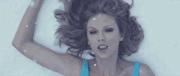 a gif of taylor swift singing in the snow in the &quot;out of the woods&quot; music video