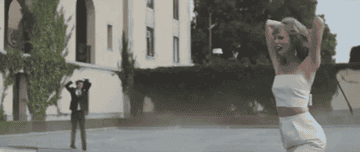 a gif of taylor swift hitting a car with a golf club in the &quot;blank space&quot; music video