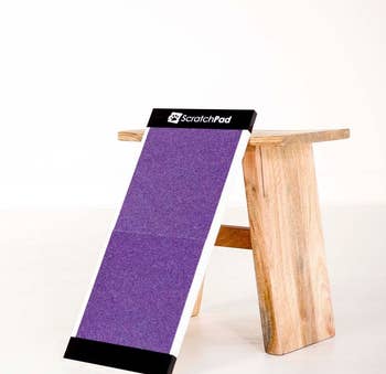 The purple scratch pad leaning against a wooden stool