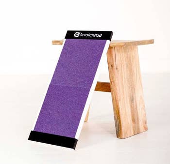 The purple scratch pad leaning against a wooden stool