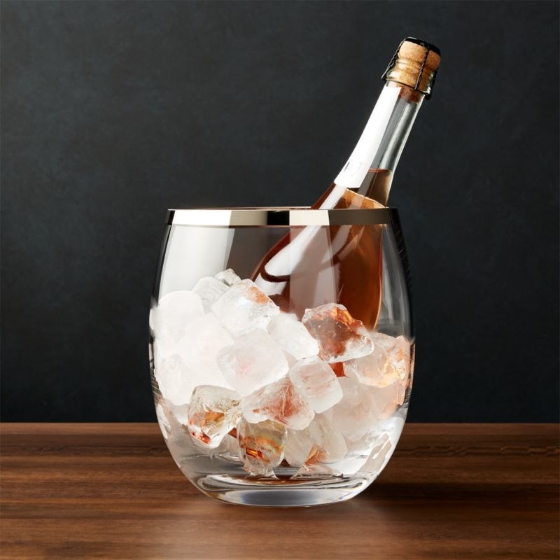 Glass champagne bucket filled with ice and a bottle