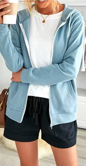 a different model wears the hoodie in baby blue