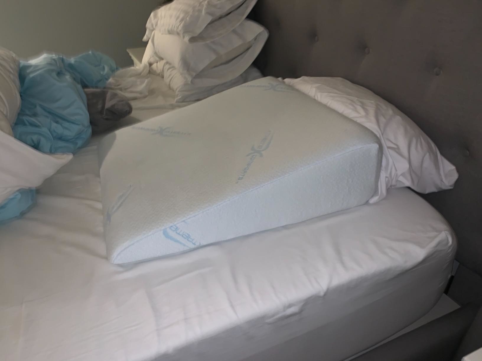 reviewer image of the wedge pillow on a bed