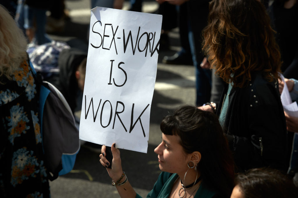 Someone holds up a sign that says &quot;Sex Work is Work&quot; during International Women&#x27;s Day in Toulouse, France