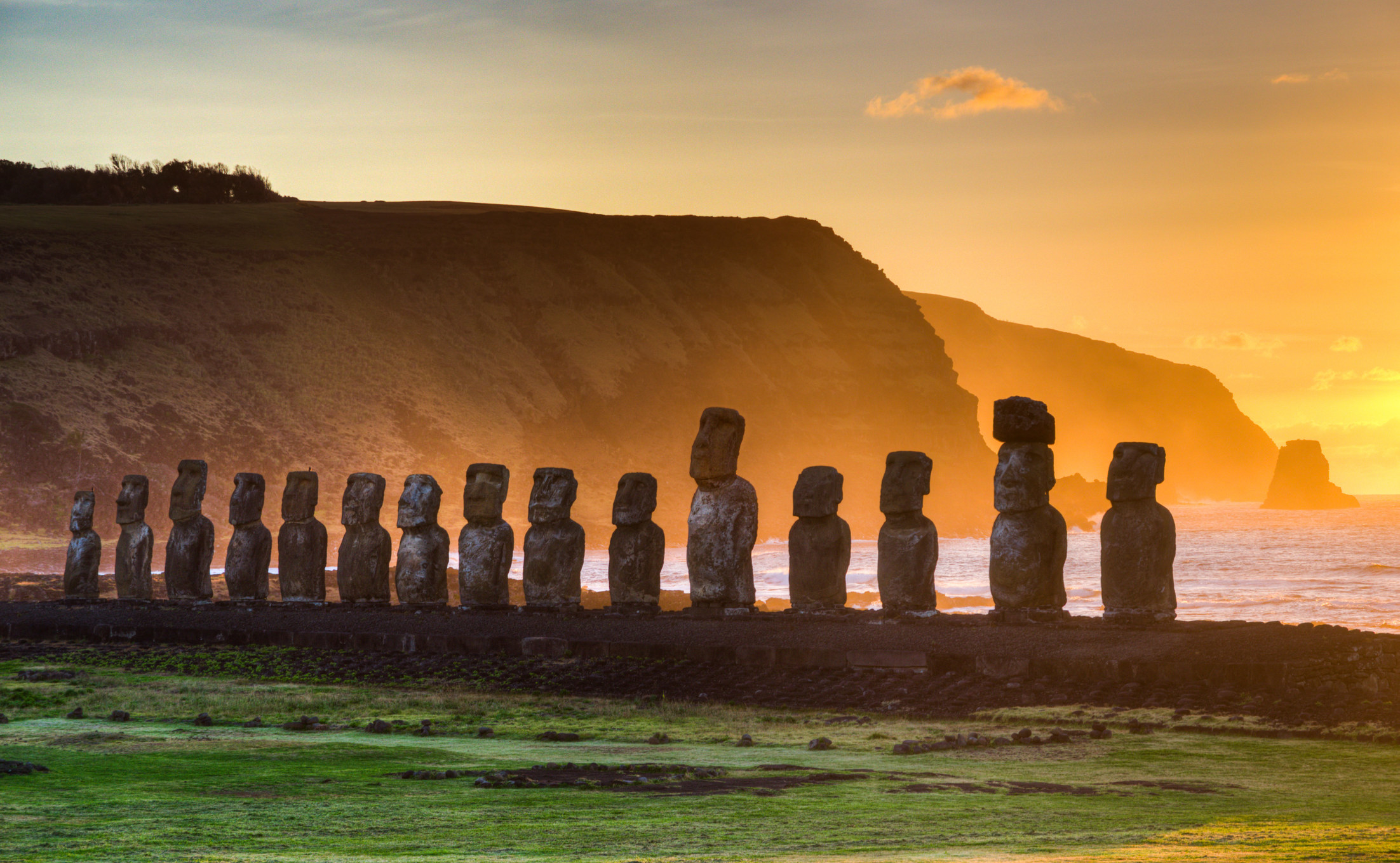 Sunrise on Easter Island with statues lined up.