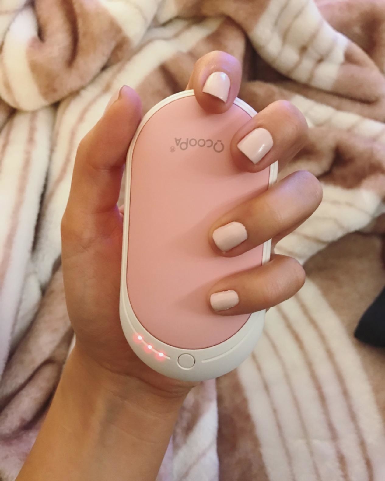 reviewer photo, holding portable handwarmer in pink