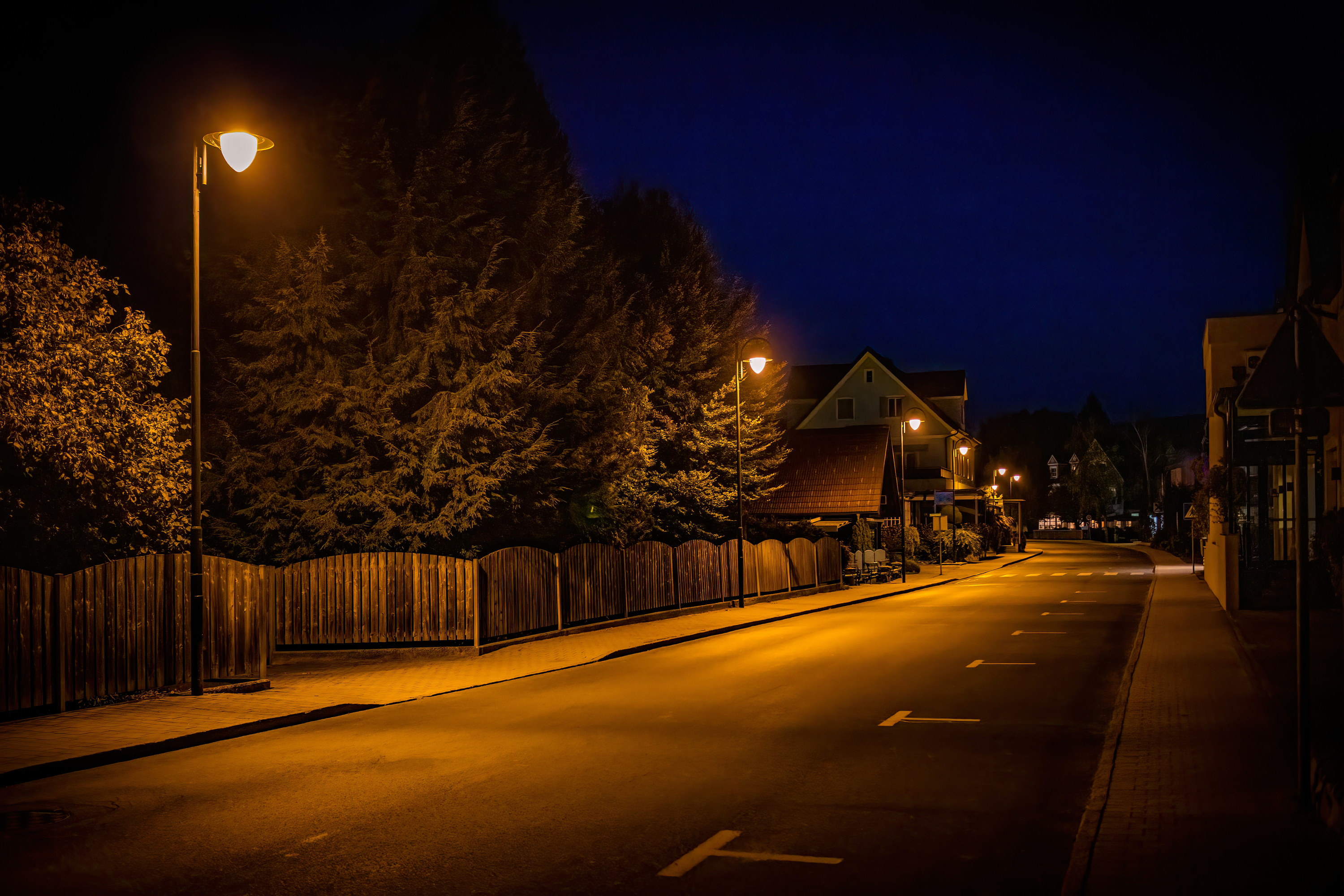 Quiet street late at night, lit by streetlights