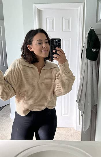 a reviewer wears the sweater in tan