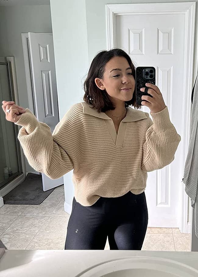 a reviewer wears the sweater in tan