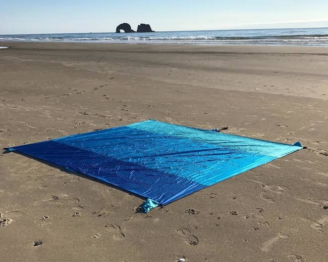 Reviewer image of multi-blue colored blanket on the beach