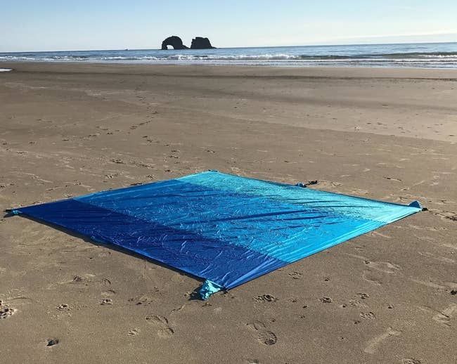 Reviewer image of multi-blue colored blanket on the beach