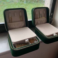 two cases with the mirror folded down revealing hooks and a pocket for necklaces