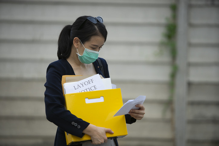 A woman walking out of her office after being laid off