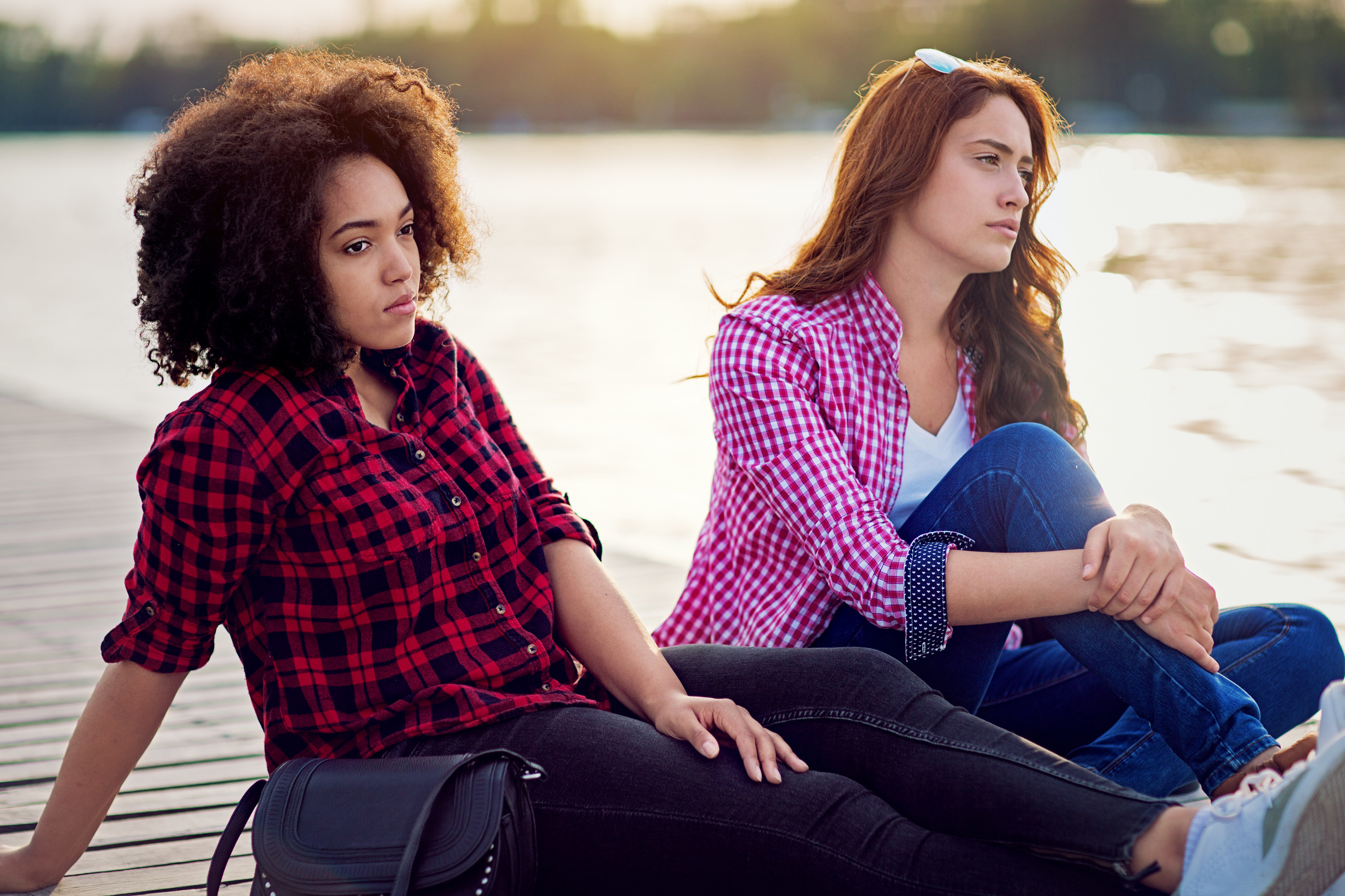 A couple sitting down and looking at a lake