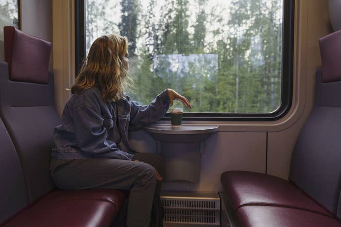 A woman looking out of a train window.