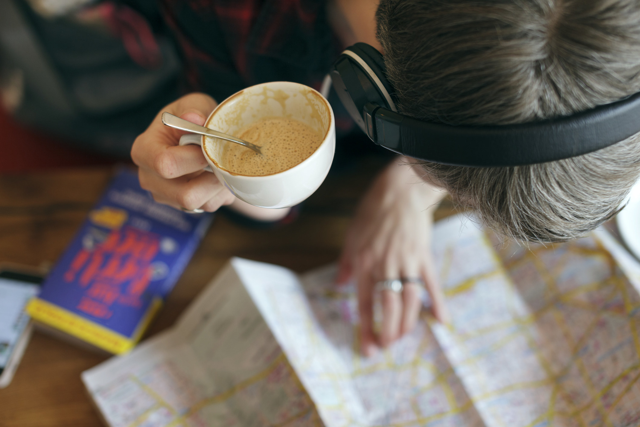 Someone looking at a map with a coffee in hand