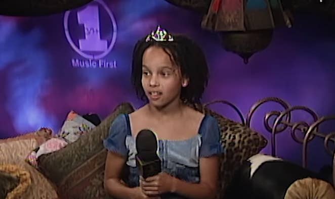 11-year-old Zöe sits on a couch with a microphone