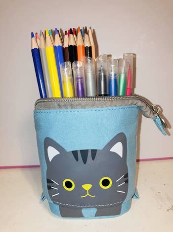 the pouch pushed down to show that it can hold a lot of pens and pencils