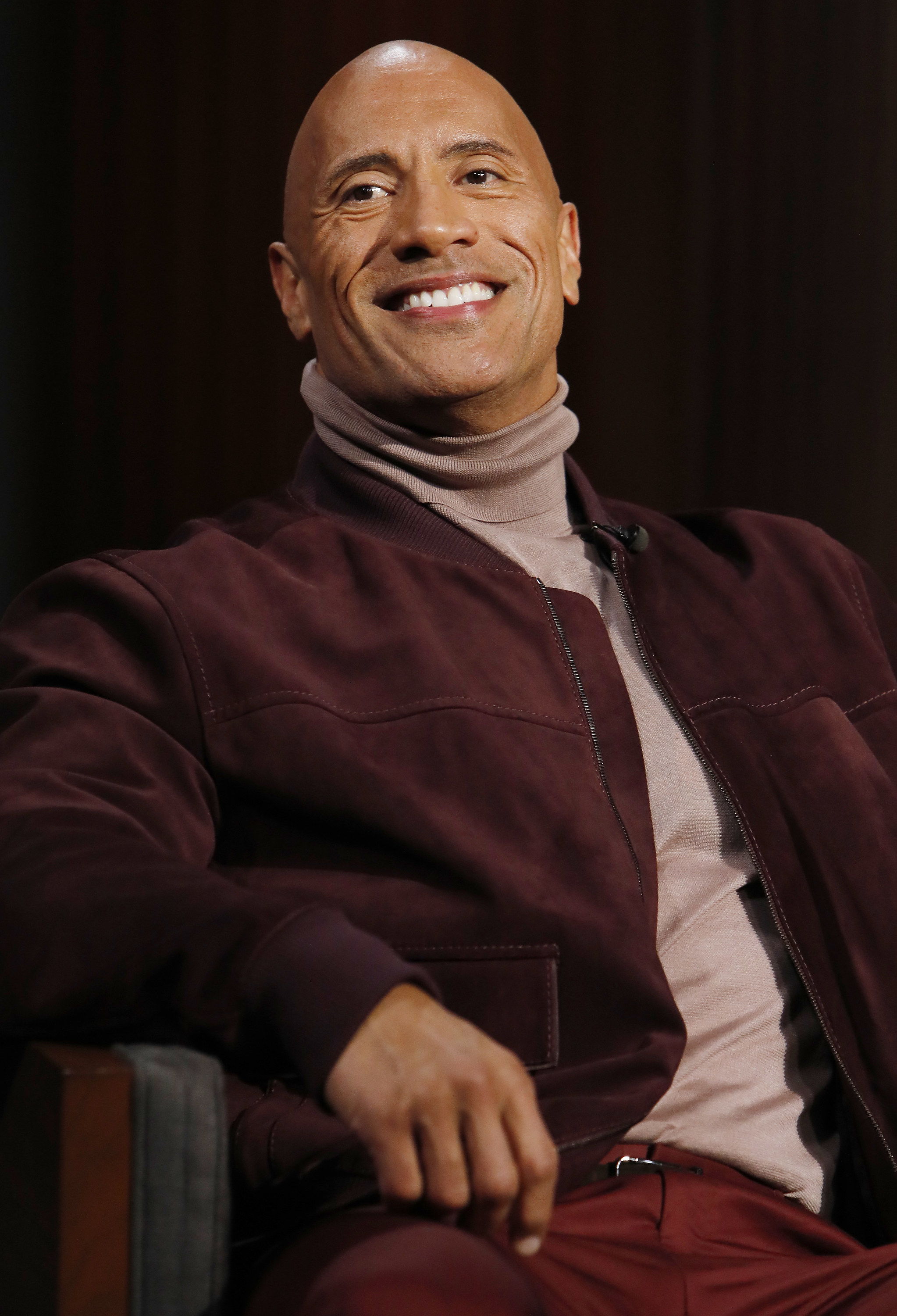 Dwayne Johnson seated and smiling