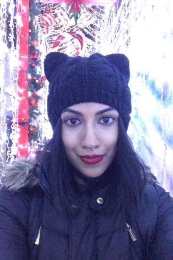 A reviewer wearing the same cat ear beanie in black