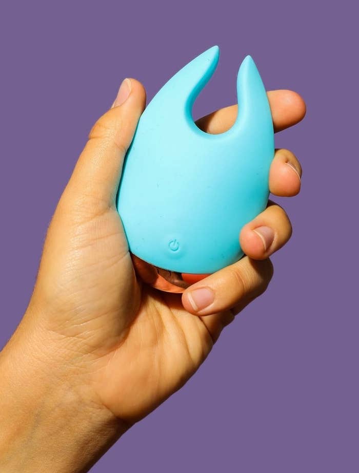 Model holding teal clitoral vibrator