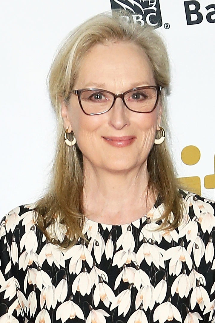 Meryl is wearing a floral shirt and glasses