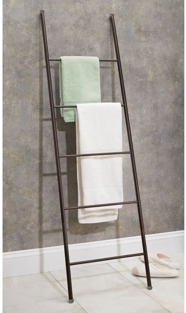 The ladder filled with towels leaning on a wall