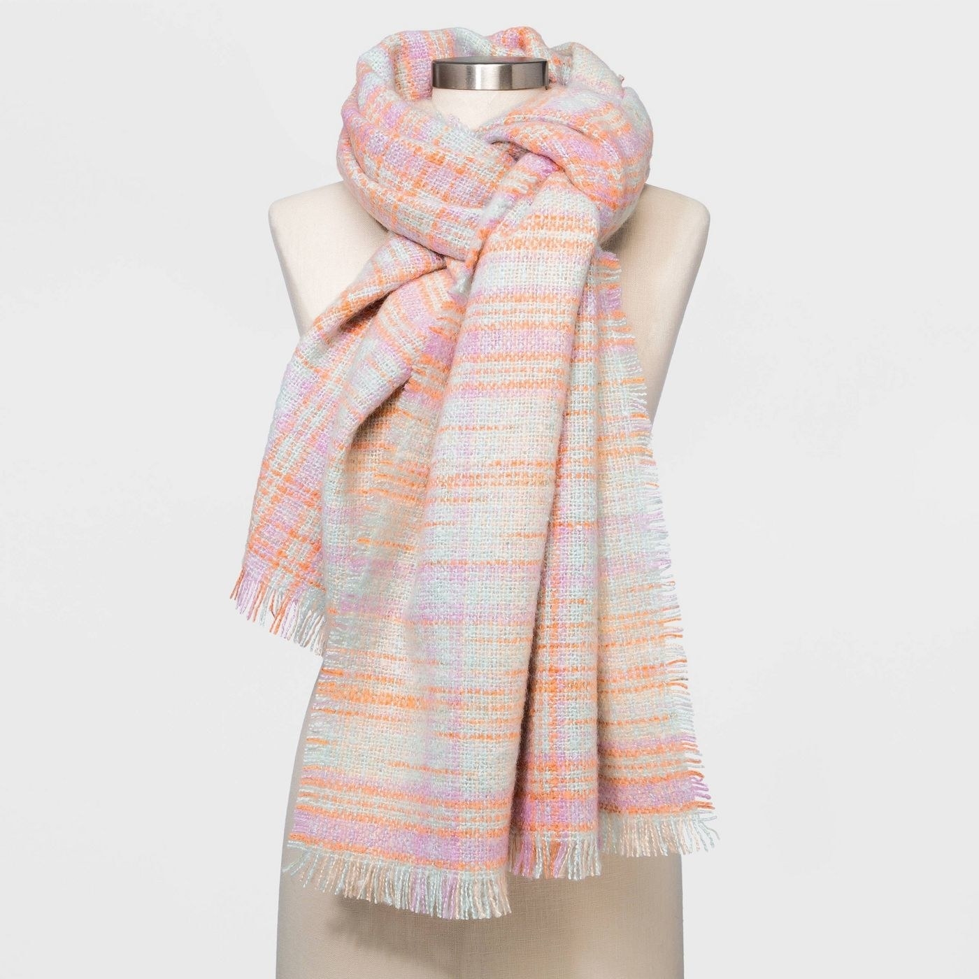 A pastel pink and orange scarf on a mannequin