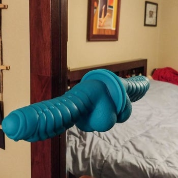 Blue textured dildo attached to mirror