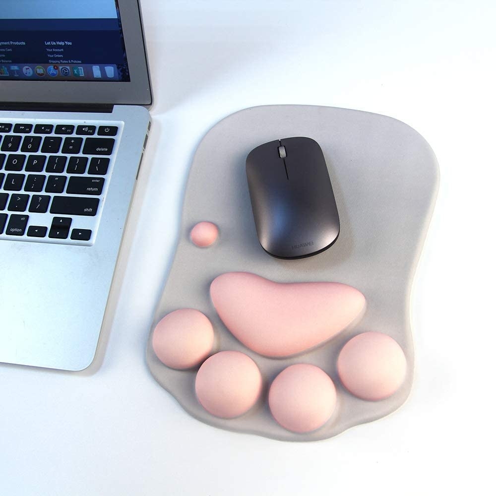 A gray mouse pad with light pink cushions in the shape of a cat paw for wrist support