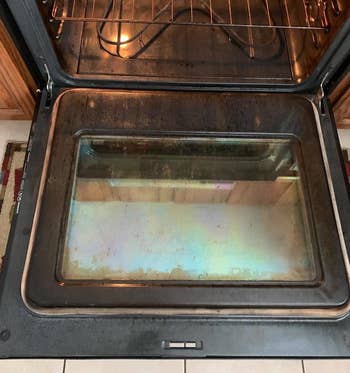 Reviewer photo of dirty oven after using Goo Gone cleaner