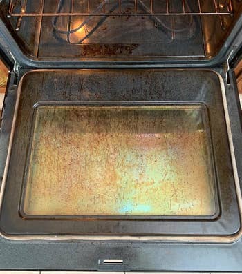 Reviewer photo of dirty oven before using Goo Gone cleaner