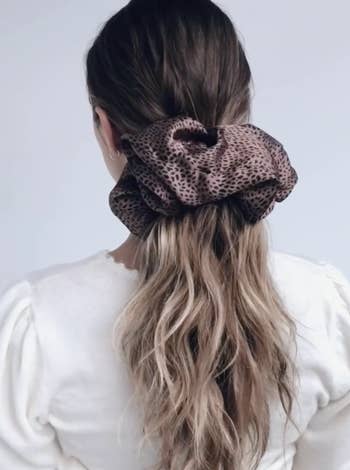 a model wearing the cheetah-print scrunchie