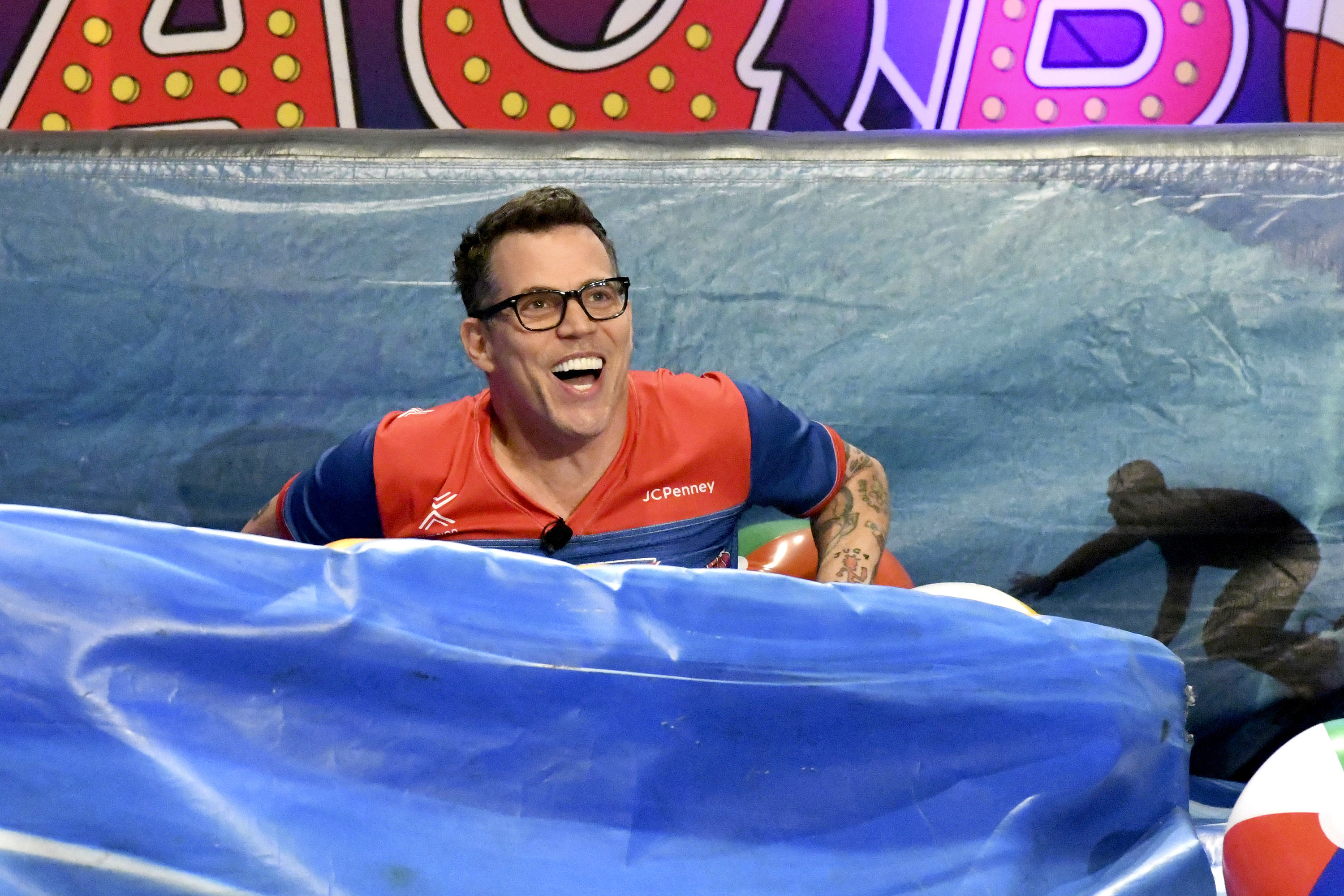 Steve O laughing while siting in a stunt airbag
