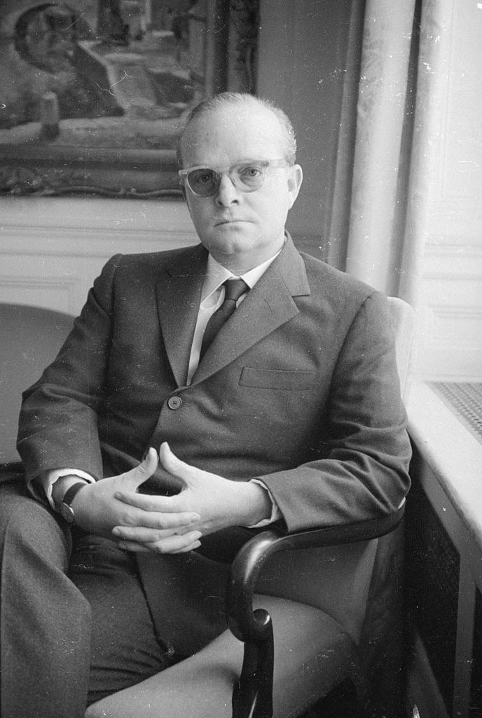 Capote posing for a portrait in a chair in 1966