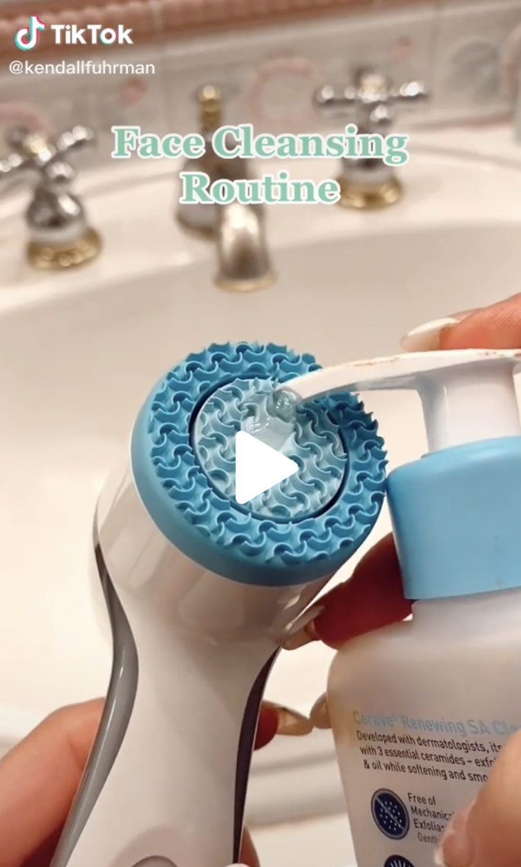 A cleanser being squeezed onto a silicone face cleansing brush